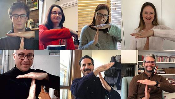 A collage of 7 smiling people making a ‘T’ shape with their hands whilst in a video conference