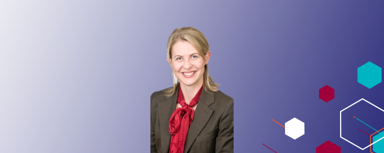 A photo of a professionally dressed woman on an abstract background that fades from white to deep purple horizontally. On the right side are abstract hexagons of different colours