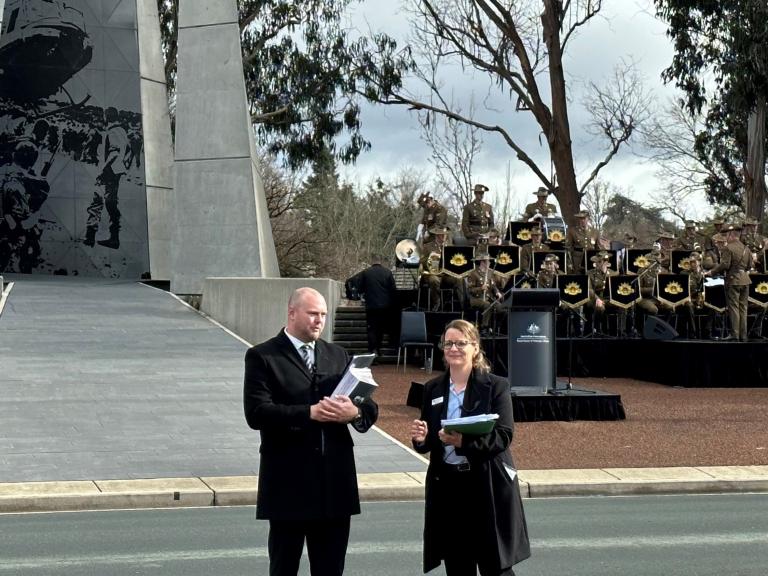 Veterans’ Affairs Rory Walker and Elspeth Forster at the Australian Vietnam Forces National Memorial in Canberra standing in front of the Army band. 