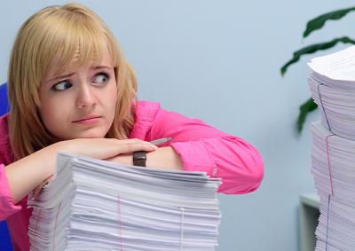 Recruitment panellist looking overwhelmed at huge stack of applications.