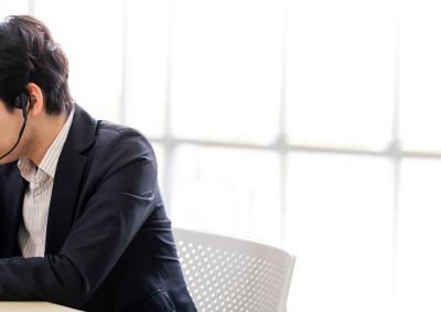 Person sitting at desk with head in hand