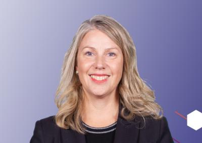 An image of Deborah Jenkins smiling on a purple to white gradient background with abstract hexagons on the right hand side