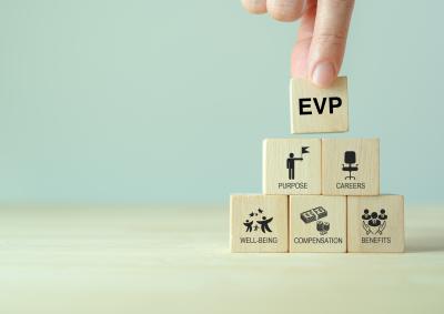 A series of small wooden blocks with someone putting a block that says EVP on top of the pile