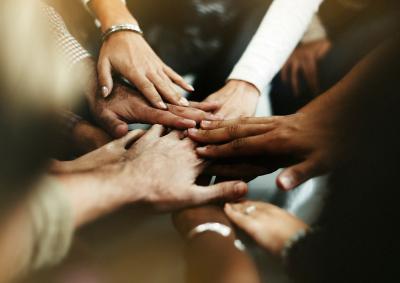 A group of people all put their hands in the centre one overlapping the other