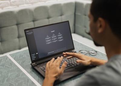 Image of office worker using an AI application on his laptop.