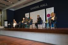 A panel of speakers sitting on a stage