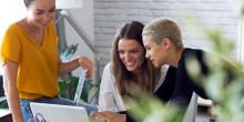 Stock photo of women looking at a laptop and smiling